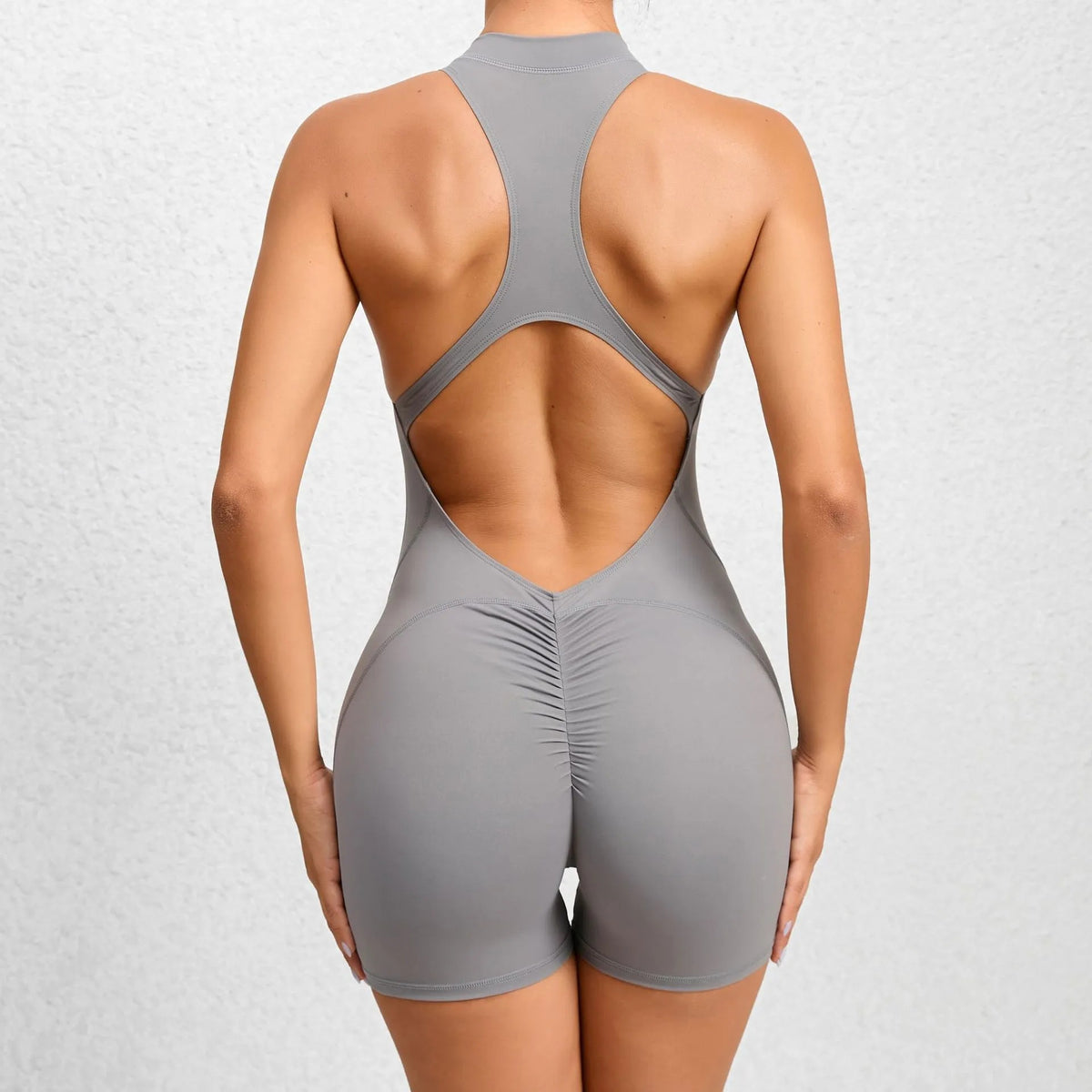 Mono corto deportivo gris con espalda abierta, vista trasera