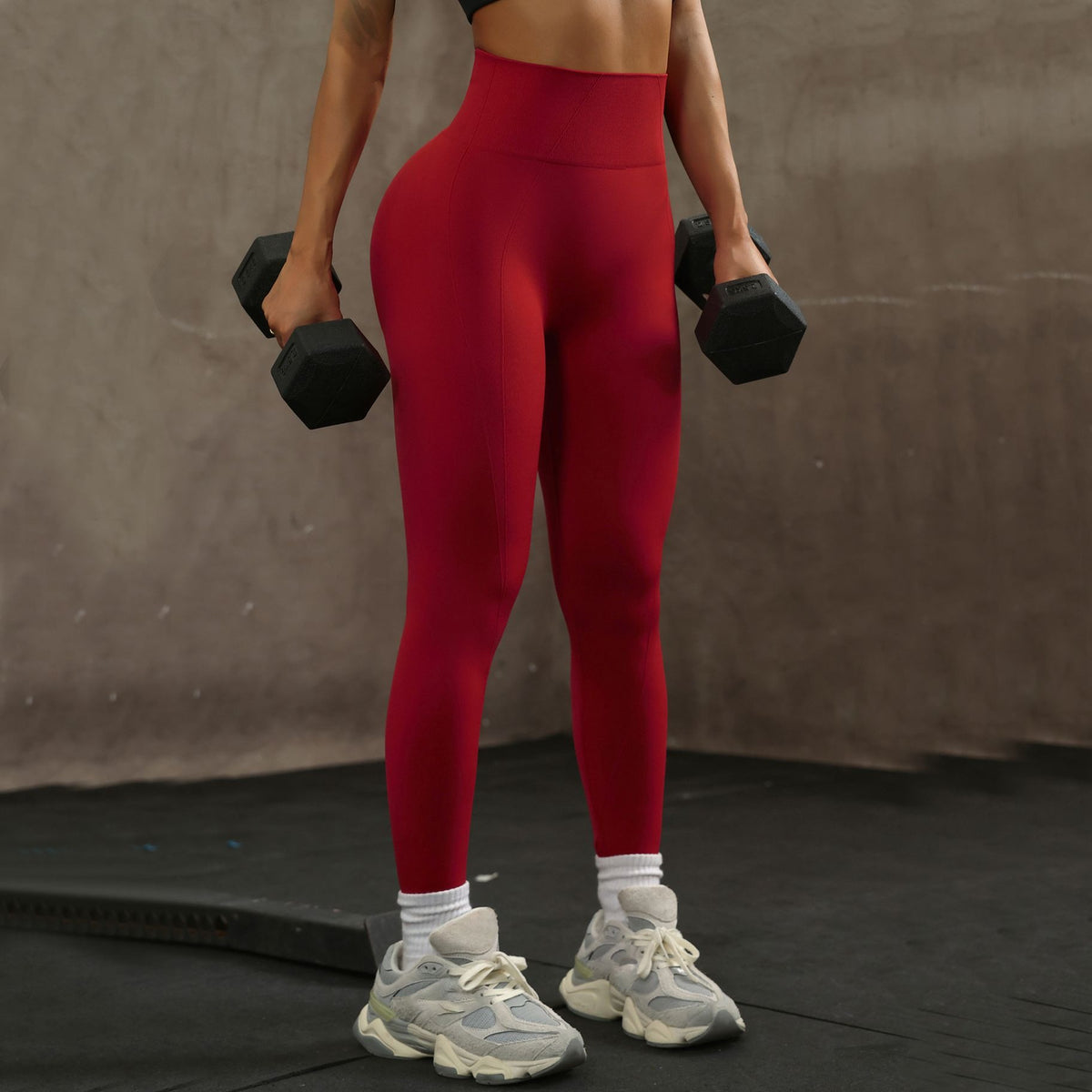 Leggings rojo vino en el gimnasio con mancuernas