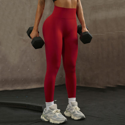 Leggings rojo vino en el gimnasio con mancuernas